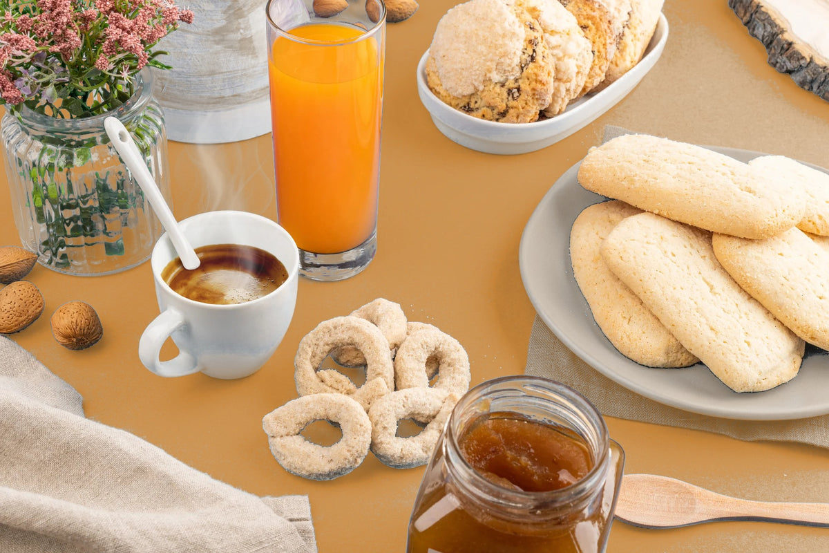 Colazione pugliese con taralli dolci, biscotti, caffè e succo d'arancia